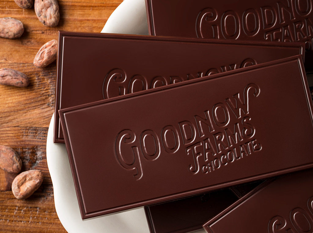 Goodnow Farms Ucayali Dark Chocolate Bars sit unwrapped on a plate with single origin cacao beans